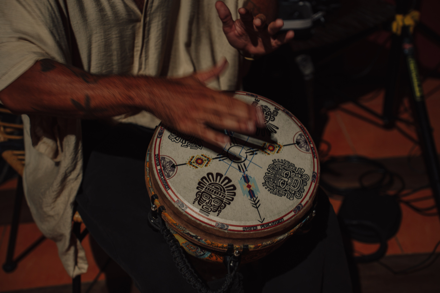 Hands playing a painted frame drum