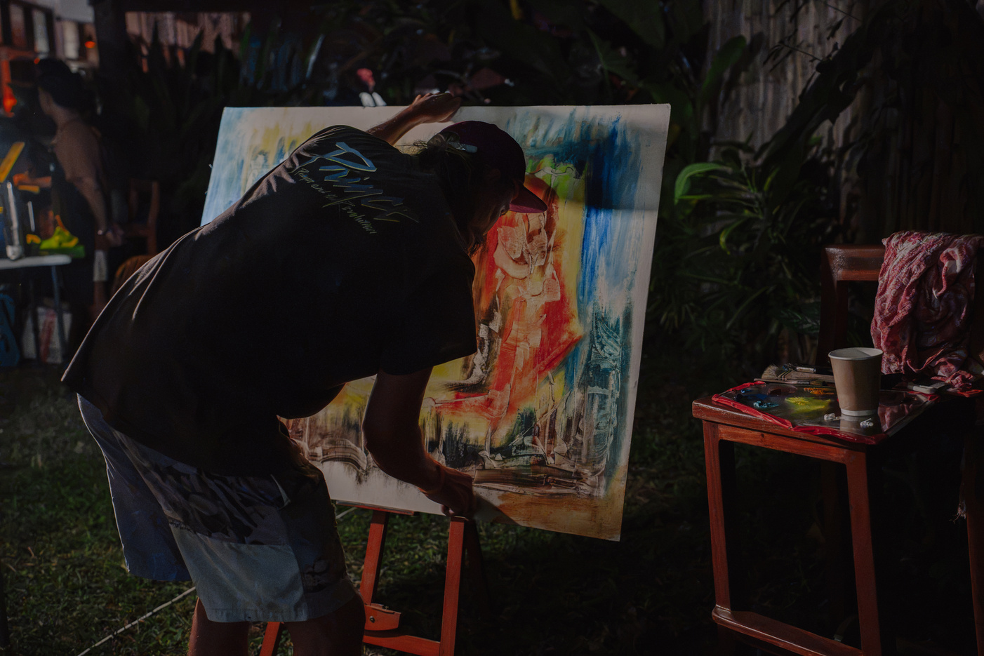An artist painting outdoors on an easel